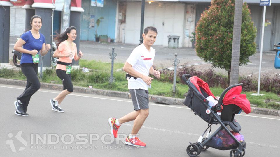 Seorang pria ikut serta dalam acara Serpong Green Warrior Run 2016 bersama bayinya.